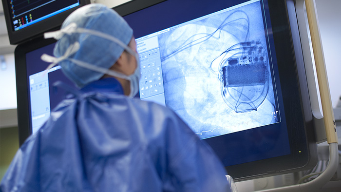 человек в халате смотрит на экран компьютера